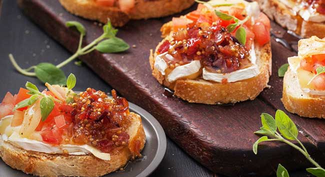 Bruschetta com Geleia de Bacon e Alhos Laminados, e Queijo Camembert e Oréganos Frescos