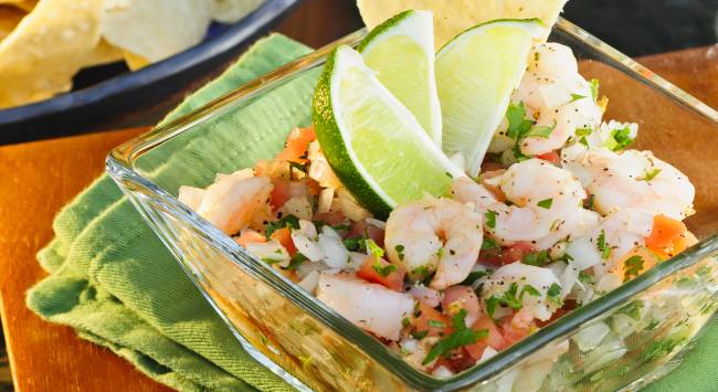 ceviche de camarão servido em pote com fatias de limão para decorar