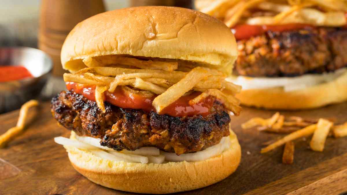 Hambúrguer frita cupana feito com carnde hambúrgue, ketchup e batatas fritas no pão brioche.