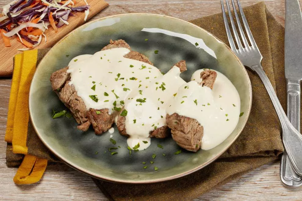 filé mignon em um prato verde com molho gorgonzola 