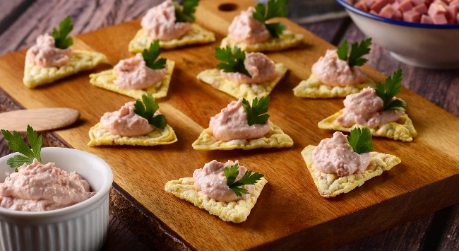 Nachos com maionese da cor rosa feita de mortadela